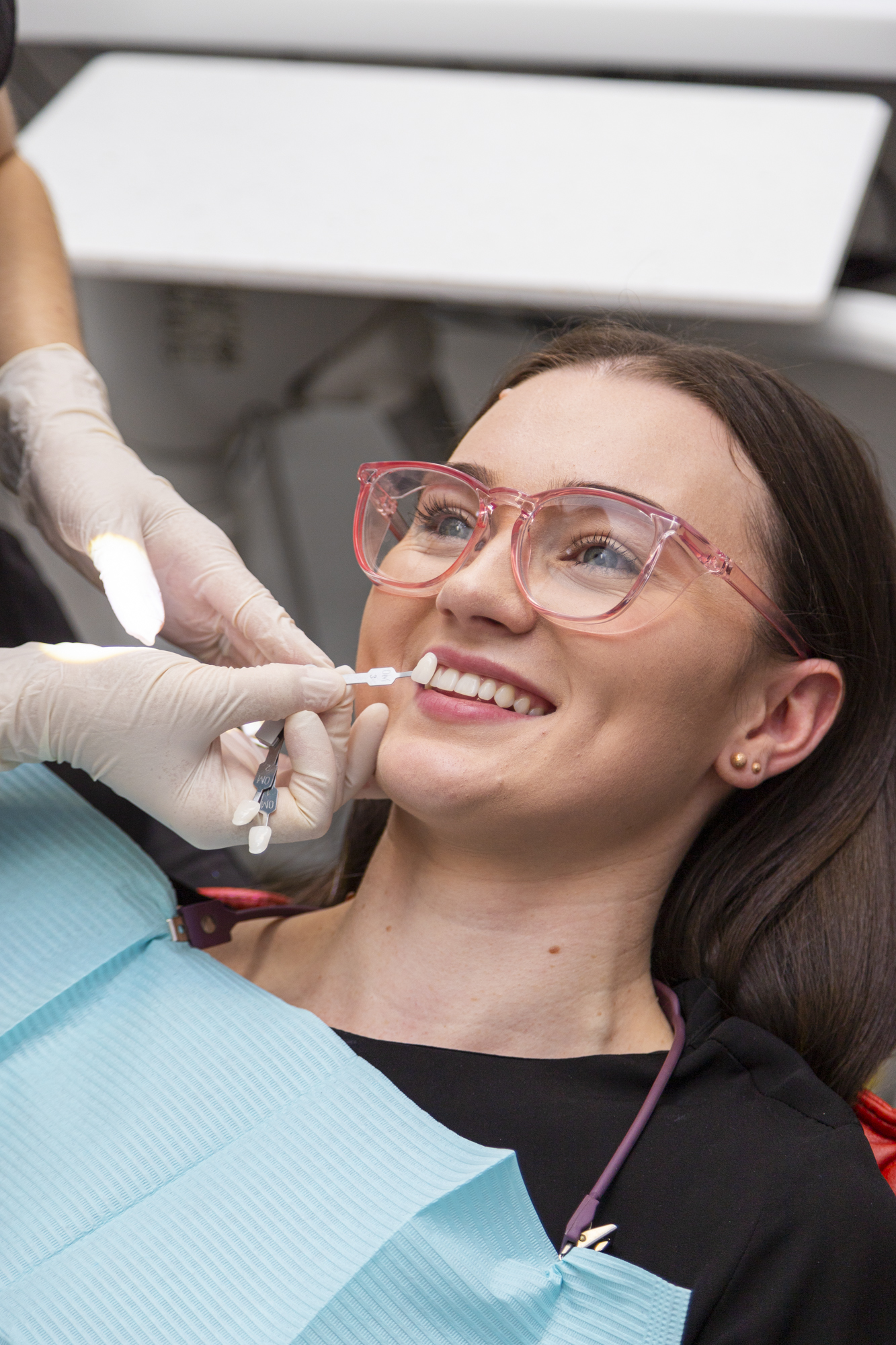 Patient in dentist chair post teeth whitening treatment.